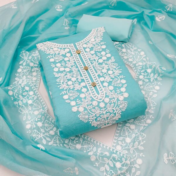 Turquoise fabric with white embroidery on a matching fabric background